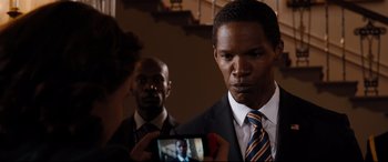 Movie still from “White House Down” (2013), directed by Roland Emmerich – A man in a suit is taking a picture of another man; Close Up shot, Over the shoulder angle