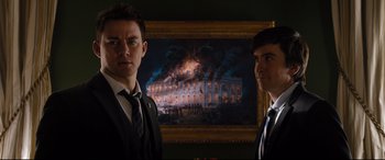 Movie still from “White House Down” (2013), directed by Roland Emmerich – Two men standing in front of a painting of a burning building; Medium shot, Low angle