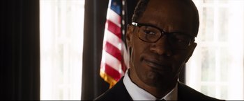 Movie still from “White House Down” (2013), directed by Roland Emmerich – A person wearing glasses and a suit; Close Up shot, Low angle