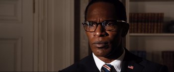 Movie still from “White House Down” (2013), directed by Roland Emmerich – A person wearing glasses and a suit; Close Up shot, Low angle