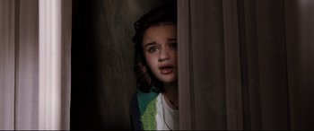 Movie still from “White House Down” (2013), directed by Roland Emmerich – A young girl is standing in a doorway looking at the camera; Close Up shot, High angle