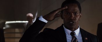 Movie still from “White House Down” (2013), directed by Roland Emmerich – A man in a suit and tie saluting with one hand; Close Up shot, Low angle