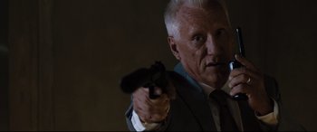 Movie still from “White House Down” (2013), directed by Roland Emmerich – An older man in a suit and tie holding a gun; Close Up shot, Over the shoulder angle