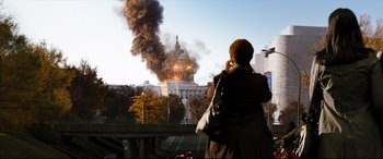 Movie still from “White House Down” (2013), directed by Roland Emmerich – A woman taking a picture of a building on fire; Extreme Wide shot, Low angle