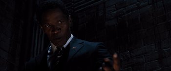 Movie still from “White House Down” (2013), directed by Roland Emmerich – A man wearing a suit and tie in front of a brick wall; Close Up shot, High angle