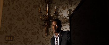 Movie still from “White House Down” (2013), directed by Roland Emmerich – A man standing in front of a wall with candles; Close Up shot, Low angle