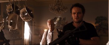 Movie still from “White House Down” (2013), directed by Roland Emmerich – Two men are standing in a living room holding guns; Medium shot, Low angle