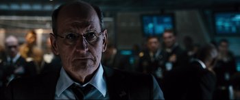 Movie still from “White House Down” (2013), directed by Roland Emmerich – An older man wearing glasses and a suit; Close Up shot, Over the shoulder angle