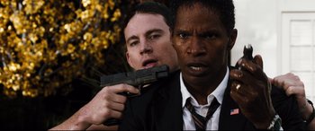 Movie still from “White House Down” (2013), directed by Roland Emmerich – A man holding a gun next to another man; Close Up shot, Over the shoulder angle