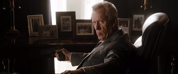 Movie still from “White House Down” (2013), directed by Roland Emmerich – An older man holding a gun in a room; Close Up shot, Low angle