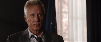 Movie still from “White House Down” (2013), directed by Roland Emmerich – An older man in a suit and tie looking at the camera; Close Up shot, Over the shoulder angle