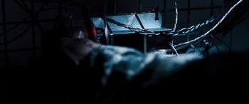 Movie still from “White House Down” (2013), directed by Roland Emmerich – A dark room with a bed and a table; Extreme Close Up shot, High angle