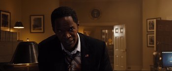 Movie still from “White House Down” (2013), directed by Roland Emmerich – A man wearing a suit and tie in a room; Close Up shot, Over the shoulder angle