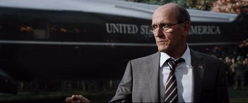 Movie still from “White House Down” (2013), directed by Roland Emmerich – A man in a suit and tie standing in front of a boat; Close Up shot, Low angle