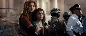 Movie still from “White House Down” (2013), directed by Roland Emmerich – A woman and a girl standing next to a man in military fatigues; Medium shot, Low angle