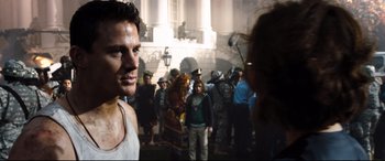 Movie still from “White House Down” (2013), directed by Roland Emmerich – A man standing in front of a group of people; Medium shot, Over the shoulder angle
