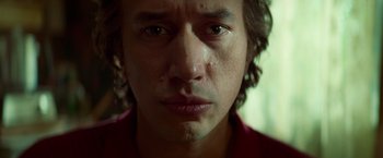 Movie still from “White Noise” (2022), directed by Noah Baumbach – A man's face in a red shirt; Close Up shot, Low angle