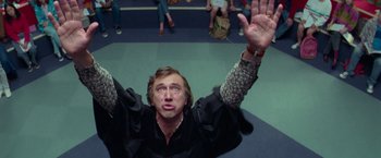 Movie still from “White Noise” (2022), directed by Noah Baumbach – A man with his hands up in the air; Medium shot, Overhead angle