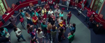 Movie still from “White Noise” (2022), directed by Noah Baumbach – A group of people standing around in a circle; Wide shot, Overhead angle