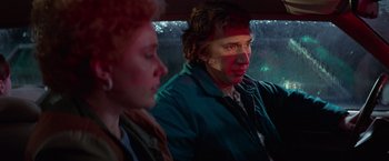 Movie still from “White Noise” (2022), directed by Noah Baumbach – A man and a woman sitting in a car looking out the window; Close Up shot, Over the shoulder angle