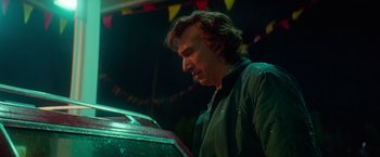 Movie still from “White Noise” (2022), directed by Noah Baumbach – A man standing in front of a car in the rain; Medium shot, Low angle