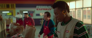 Movie still from “White Noise” (2022), directed by Noah Baumbach – A group of people standing around a store; Medium shot, Over the shoulder angle