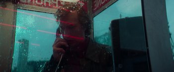 Movie still from “White Noise” (2022), directed by Noah Baumbach – A man talking on a phone in front of a store window; Close Up shot, Low angle