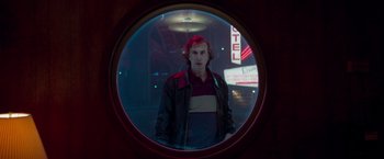 Movie still from “White Noise” (2022), directed by Noah Baumbach – A man standing in front of a hotel window; Medium shot, Low angle