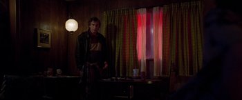 Movie still from “White Noise” (2022), directed by Noah Baumbach – A man standing in front of a window in a room; Medium shot, Over the shoulder angle