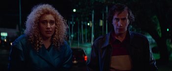 Movie still from “White Noise” (2022), directed by Noah Baumbach – A man and a woman standing next to each other on a street; Medium shot, Over the shoulder angle