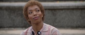 Movie still from “Whitney Houston: I Wanna Dance with Somebody” (2022), directed by Kasi Lemmons – A person with a microphone in their ears; Close Up shot, Over the shoulder angle