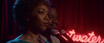 Movie still from “Whitney Houston: I Wanna Dance with Somebody” (2022), directed by Kasi Lemmons – A woman and a man sing into microphones; Close Up shot, Over the shoulder angle