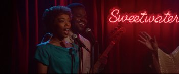 Movie still from “Whitney Houston: I Wanna Dance with Somebody” (2022), directed by Kasi Lemmons – A couple of people singing into microphones in a room; Medium shot, Over the shoulder angle