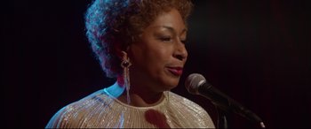 Movie still from “Whitney Houston: I Wanna Dance with Somebody” (2022), directed by Kasi Lemmons – A person singing on a microphone; Close Up shot, Low angle