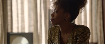 Movie still from “Whitney Houston: I Wanna Dance with Somebody” (2022), directed by Kasi Lemmons – A person wearing a gold jacket; Close Up shot, Over the shoulder angle