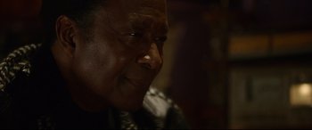 Movie still from “Whitney Houston: I Wanna Dance with Somebody” (2022), directed by Kasi Lemmons – An older man is looking into the distance; Close Up shot, Over the shoulder angle