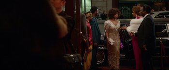 Movie still from “Whitney Houston: I Wanna Dance with Somebody” (2022), directed by Kasi Lemmons – A group of people standing next to each other in a room; Wide shot, Over the shoulder angle