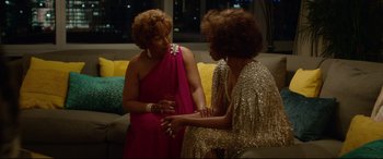 Movie still from “Whitney Houston: I Wanna Dance with Somebody” (2022), directed by Kasi Lemmons – Two women are talking to each other at a party; Medium shot, Over the shoulder angle