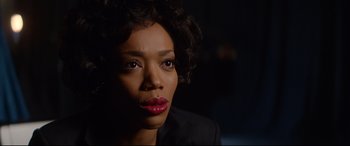 Movie still from “Whitney Houston: I Wanna Dance with Somebody” (2022), directed by Kasi Lemmons – A person wearing a suit and red lipstick; Close Up shot, Over the shoulder angle