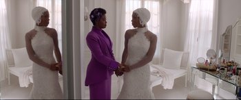 Movie still from “Whitney Houston: I Wanna Dance with Somebody” (2022), directed by Kasi Lemmons – Two women holding hands while standing next to each other in a room; Medium shot, Over the shoulder angle