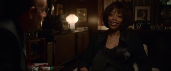 Movie still from “Whitney Houston: I Wanna Dance with Somebody” (2022), directed by Kasi Lemmons – A woman sitting in a chair in front of a lamp; Medium shot, Over the shoulder angle