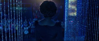 Movie still from “Whitney Houston: I Wanna Dance with Somebody” (2022), directed by Kasi Lemmons – A woman in a black dress is looking at a crowd of onlookers; Medium shot, Over the shoulder angle