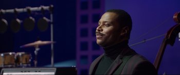 Movie still from “Whitney Houston: I Wanna Dance with Somebody” (2022), directed by Kasi Lemmons – A man in a black jacket is looking to his left; Close Up shot, Over the shoulder angle