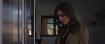 Movie still from “Windfall” (2022), directed by Charlie McDowell – A beautiful young lady standing next to a window; Close Up shot, Over the shoulder angle