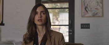 Movie still from “Windfall” (2022), directed by Charlie McDowell – A woman sitting in front of a window; Close Up shot, Over the shoulder angle