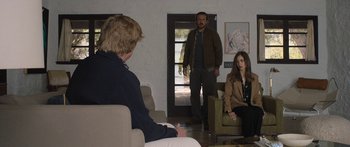 Movie still from “Windfall” (2022), directed by Charlie McDowell – A man and a woman in a living room; Wide shot, Over the shoulder angle