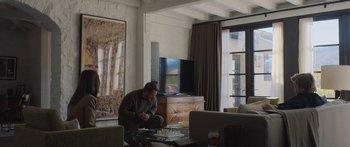 Movie still from “Windfall” (2022), directed by Charlie McDowell – A man sitting in a living room playing chess; Wide shot, Over the shoulder angle