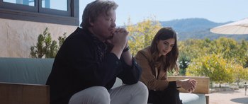 Movie still from “Windfall” (2022), directed by Charlie McDowell – A man and a woman sitting next to each other; Medium shot, Low angle