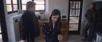 Movie still from “Windfall” (2022), directed by Charlie McDowell – A young woman holding a cup of coffee in her hands; Medium shot, Over the shoulder angle