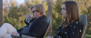 Movie still from “Windfall” (2022), directed by Charlie McDowell – A man and a woman are sitting on a bench; Medium shot, Over the shoulder angle